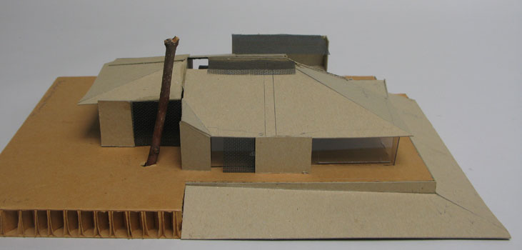 Working model for house with big roof and sliding screens for glass protection.  The large tree is existing, still.  Low view to water.