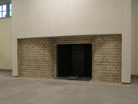 Incomplete basement fireplace with curved limestone side walls